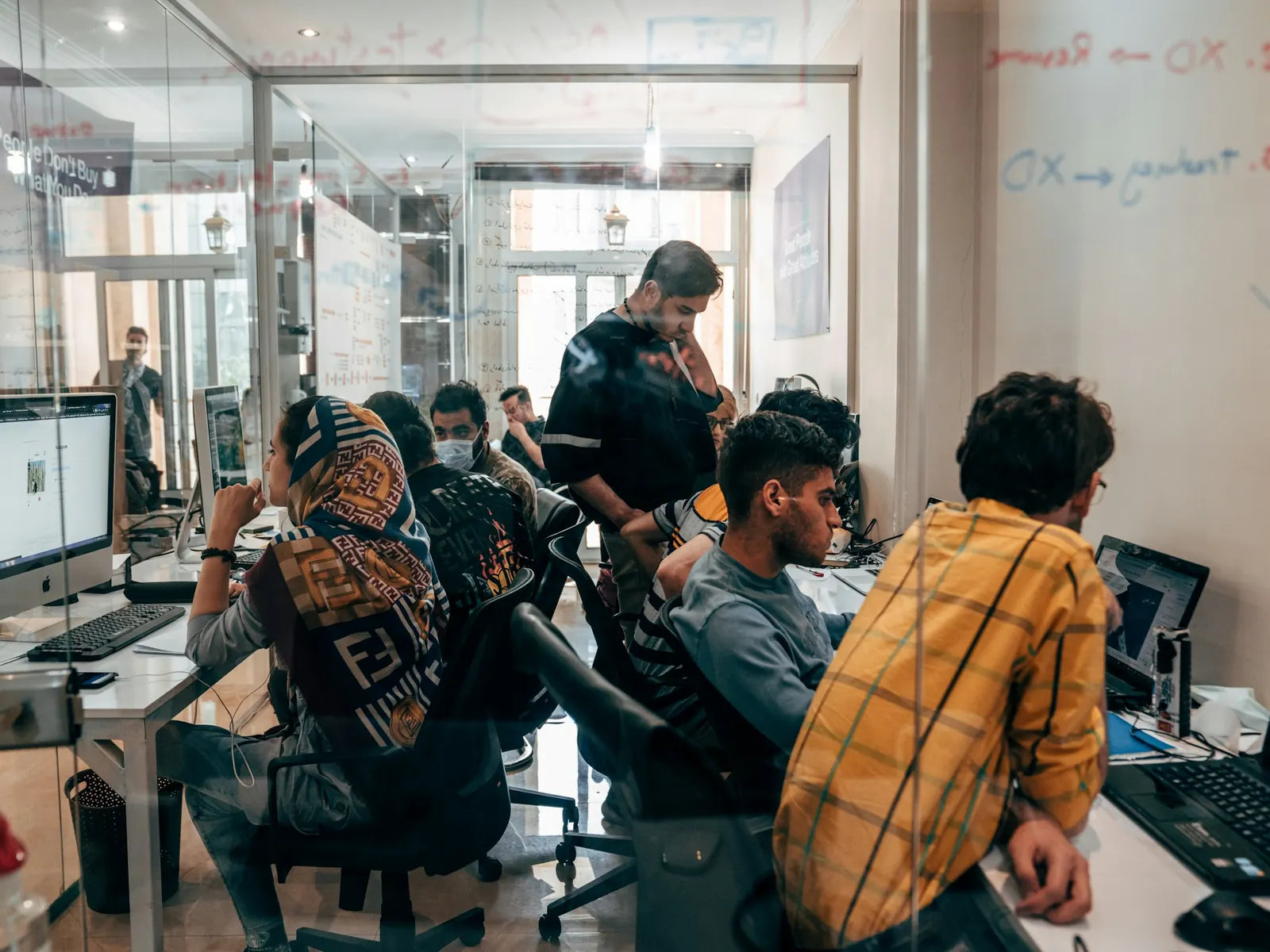 Team of professionals working together at computers in a busy office