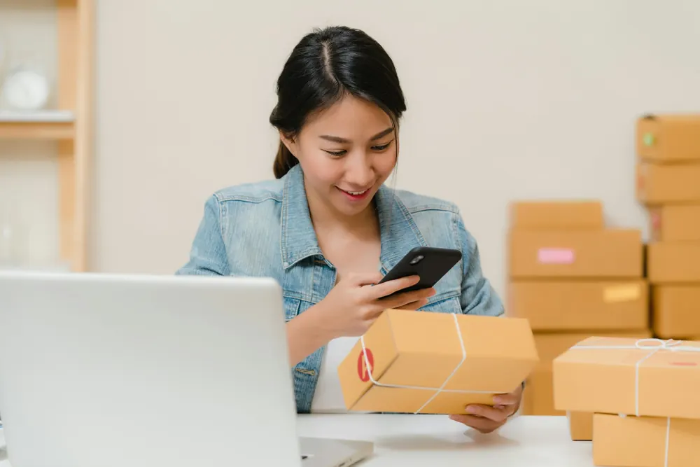 Online seller checking a parcel order on a phone