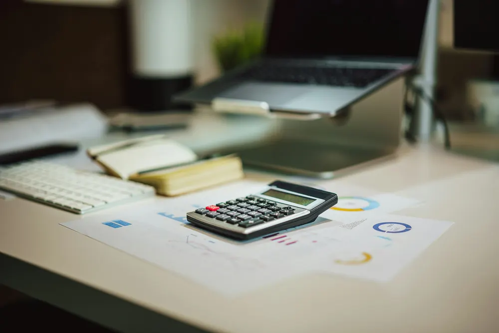 Calculator and financial reports on an office desk